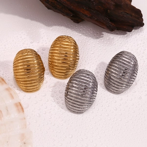Oval striped texture earrings in gold and silver finish on a nature inspired backdrop