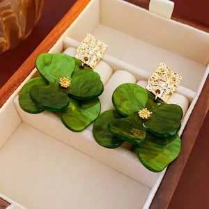 Vintage green flower earrings with gold textured metal studs on velvet jewelry box