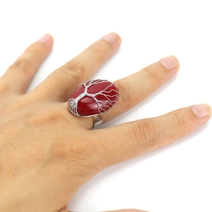 Detail of handmade wire wrapped tree of life ring with oval red crystal stone