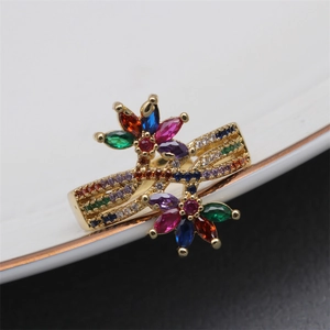 Adjustable gold flower ring with colorful micro-pave crystals on a white plate