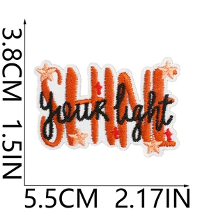 Detail of Shine Your Light embroidered patch with orange text and precise dimensions