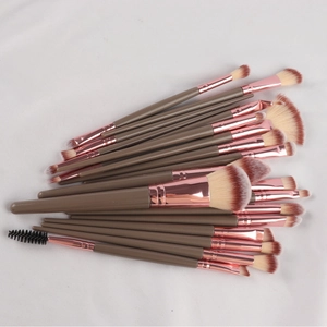 Macro shot of a professional makeup brush set with rose gold ferrules and brown handles