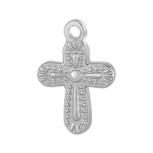 Détail d'un pendentif croix argenté avec motifs à points en relief et anneau de suspension