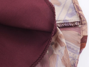 Detailed macro view of bohemian paisley chiffon fabric with professional overlock stitching
