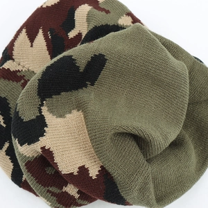 Detail of camouflaged knitted beanie showing thick fabric texture and olive green lining