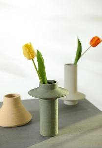 Close-up of matte textured ceramic vases with tulips in a modern minimalist setting