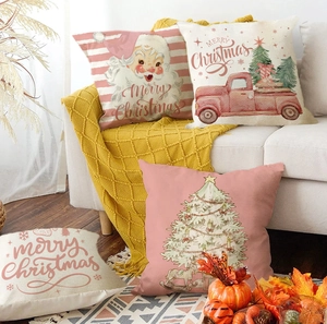 Close-up of vintage Christmas pillow covers with Santa and red truck on a cozy white sofa