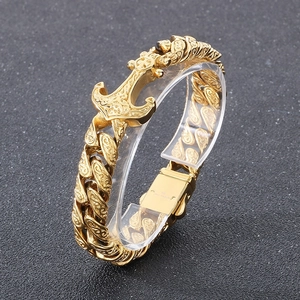 Macro shot of gold anchor bracelet with engraved patterns and stainless steel clasp detail