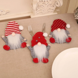 Trois porte-couverts de noël gnomes avec chapeaux festifs sur nappe en lin