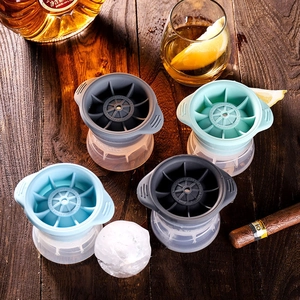 Silicone sphere ice ball maker set in four colors for whiskey on dark wood table