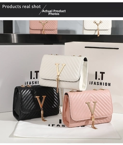 Detail of crossbody bags with V-shaped gold hardware, tassels, and quilted pattern texture
