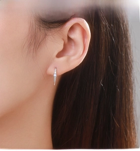 Detailed close-up of S925 silver drop earring with micro-set zircon and opal on model