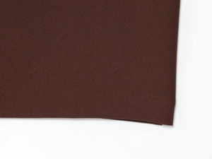 Close-up of deep brown crepe fabric showing fine woven texture and durable material quality