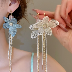 Detail of long floral drop earrings with blue lace petals and cascading crystal tassels