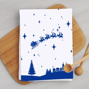 Detailed Christmas dish towel featuring Santa and reindeer on a wooden board