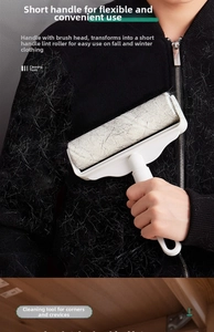 Close-up of white ergonomic lint roller removing pet hair from black clothing effectively