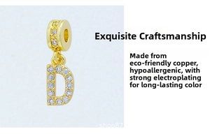 Macro detail of gold plated letter D pendant with sparkling cubic zirconia inlay