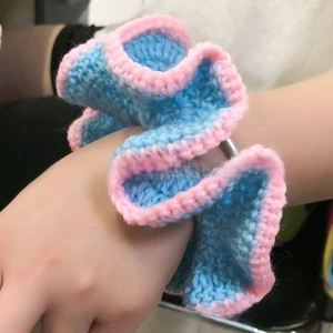 Detailed macro of a two-tone handmade crochet ruffled hair scrunchie in blue and pink