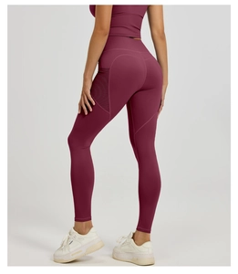 Detail of high waisted yoga leggings in dark wine red with side mesh pocket design