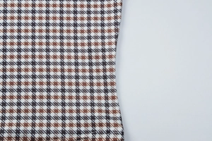 Gros plan détaillé de la texture du tissu pied-de-poule marron et de l'ourlet de l'ensemble