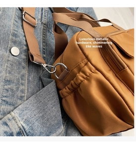 Details der braunen Nylon-Kissentasche mit silbernen Beschlägen und verstellbarem Gurt