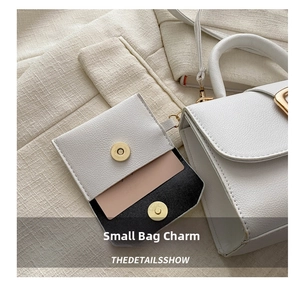 Macro shot of white lychee leather mini charm bag with gold magnetic buckle and card slot