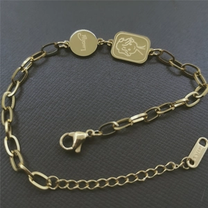 Detail of gold stainless steel bracelet with Lucky disk and cartoon character pendant