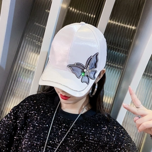 Elegant white satin baseball cap with butterfly rhinestone detail shown on a model