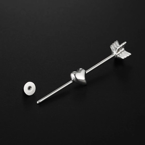 Macro detail of silver stainless steel industrial barbell with heart and arrow design