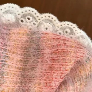 Macro shot of pink fuzzy fabric hair scrunchie with delicate white lace edging detail