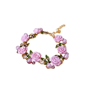 Bracelet floral avec roses en résine rose et perles sur une chaîne dorée