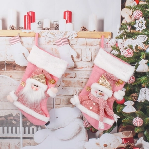 Chaussettes de Noël en peluche rose avec Père Noël et bonhomme de neige sur cheminée