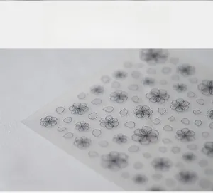 Macro shot of 5D minimalist black floral nail art stickers with translucent backing