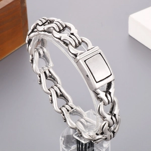 Detail view of vintage silver chain bracelet with interlocking horseshoe links on stand