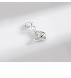 Macro detail of a 925 sterling silver hollow butterfly pendant with a white gemstone