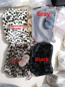 Close-up of faux fur bucket bags in leopard print and solid colors with plush pompom charms