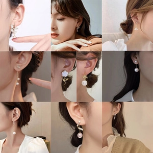Detailed close-up of various gold and pearl earrings in a professional grid display