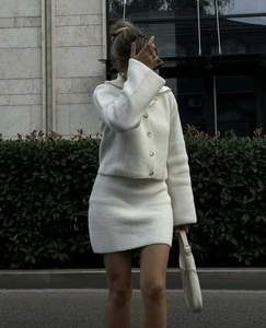 Détail de l'ensemble gilet et jupe en maille côtelée blanche à texture fine