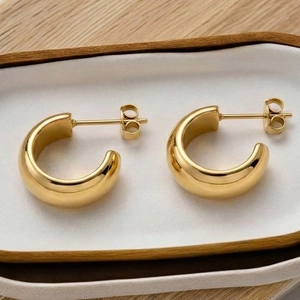 Créoles en C minimalistes en acier inoxydable plaqué or 18 carats sur plateau