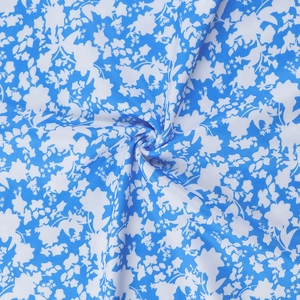 Detail of blue and white floral fabric showing soft texture and elegant plant pattern