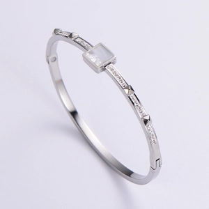 Close-up of silver bangle with square white gemstone and sparkling cubic zirconia stones