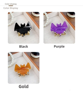 Detail view of glittery bat hair claws in black purple and gold for Halloween