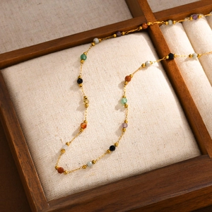 Macro view of multicolored faceted beads on a gold-plated stainless steel chain necklace