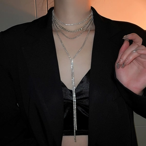Close-up of sparkling silver layered rhinestone tassel necklace on a model wearing black