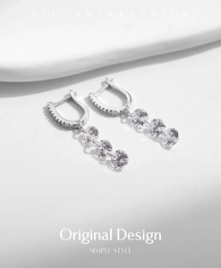 Close-up of S925 sterling silver dangle earrings with three round brilliant cubic zirconia