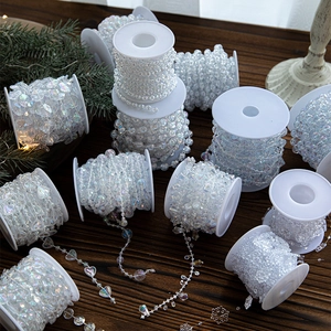 Iridescent acrylic bead garlands with heart and snowflake shapes on a wooden surface