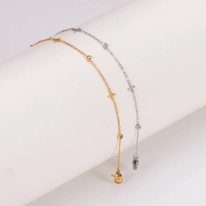Gold and silver stainless steel cross anklets with round clear stones on white stand