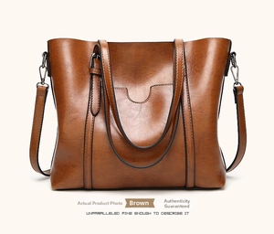 Detail of brown PU leather tote bag with sturdy handles and detachable shoulder strap