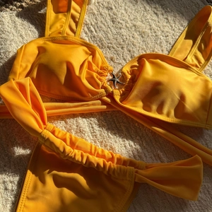 Detail of yellow bikini top featuring a sparkling rhinestone metal starfish embellishment