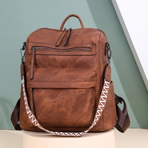 Détail d'un sac à dos en cuir PU marron avec bandoulière tissée et plusieurs poches